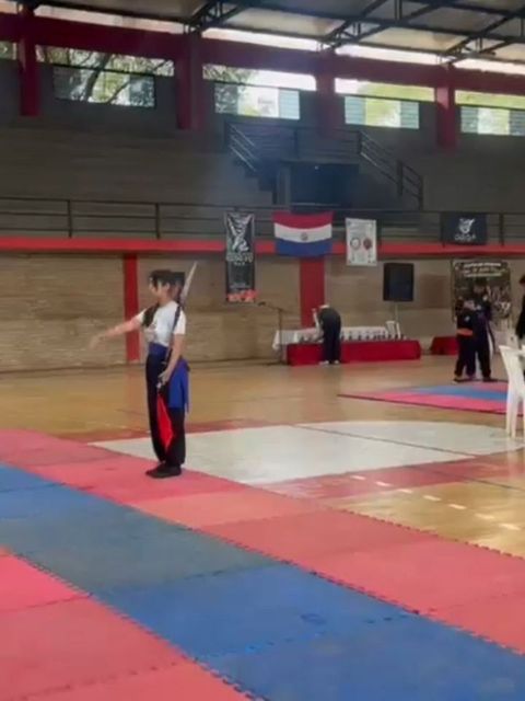 Alumno ejecutando una forma con arma en el torneo