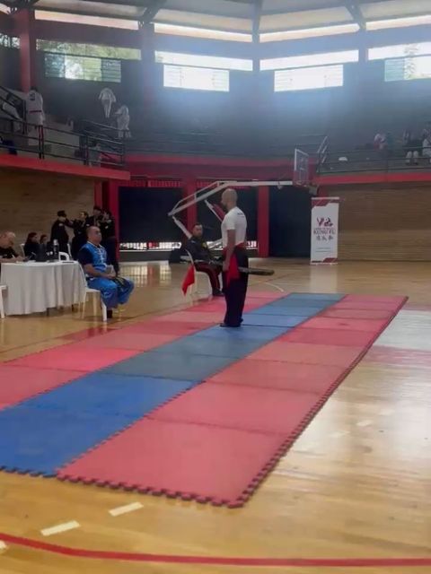 Competidor de la academia con arma tradicional, listo para su forma en el tatami